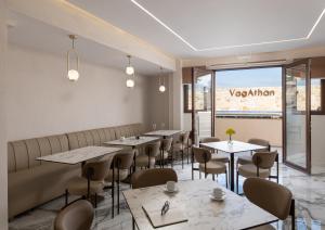 a restaurant with tables and chairs and a window at VagAthan - Lux Holidays in Afitos