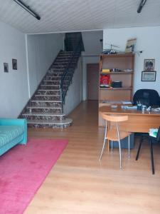 a living room with a staircase and a table and a desk at Dolce dormire in Fulgatore