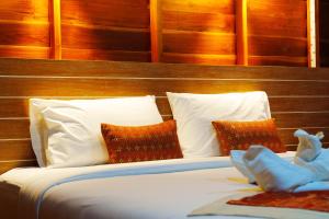 a bed with white sheets and red pillows at Doi Inthanon View Resort in Chom Thong