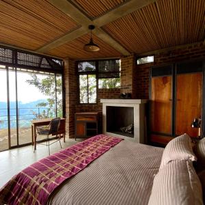 een slaapkamer met een groot bed en een open haard bij Suite en las Nubes Hotel Portal 360 in Nocaima