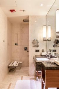baño con lavabo y espejo grande en JW Marriott Hotel Zhengzhou, en Zhengzhou