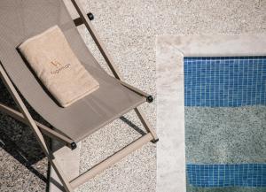 a chair with a bag on it next to a pool at VagAthan - Lux Holidays in Afitos