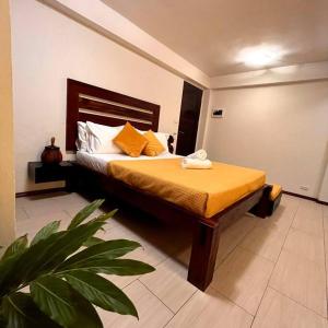 a bedroom with a bed with orange sheets and a plant at Angelina Villas_R1_Arte Casa_Malapascua in Logon