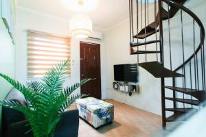 a living room with a spiral staircase and a stair case at Cozy BNB - Unit L in Batangas City