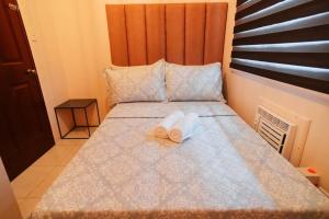 a bed with a pair of towels sitting on it at Cozy BNB - Unit L in Batangas City