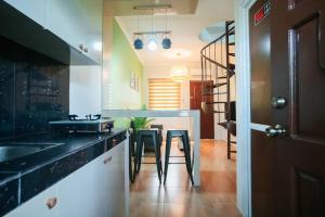 una cocina con mesa, lavabo y escalera en Cozy BNB - Unit L, en Batangas