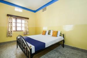 um quarto com uma cama com paredes azuis e amarelas em SPOT ON Cherish Guest House em Ranchi
