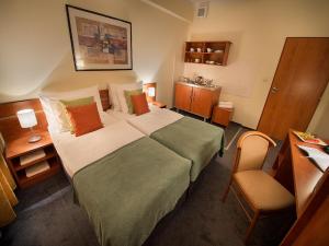 Pokój hotelowy z łóżkiem i krzesłem w obiekcie Rezidence Emmy w Pradze