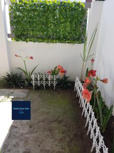 a garden with flowers next to a white wall at Stellka cheerful 2BR townhouse near the beach and city in Nasugbu