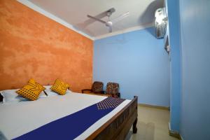 a bedroom with a bed with yellow and blue walls at SPOT ON Shashi Prabha Palace in Deoghar