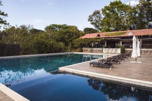 einen Pool mit Stühlen und Sonnenschirmen neben einem Resort in der Unterkunft Pintoresco in Anuling