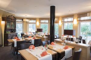 Hotel Meiners في Kirchhatten: مطعم بطاولات وكراسي خشبية ونوافذ