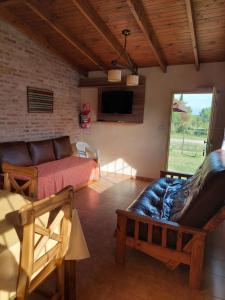 sala de estar con sofá y TV en Aroma de campo en Chascomús