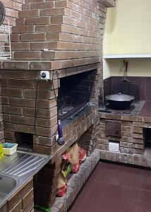 ゲニチェスクにあるGostinyi dvorik Nikolのキッチン(レンガ造りのオーブン、シンク付)