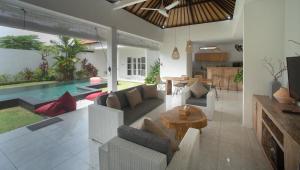 a living room with a couch and a table and a pool at Modern 3 Bedrooms Villa Beach Walking Distance in Seminyak