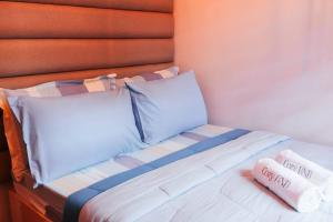 a bed with two towels sitting on top of it at Cozy BNB - Unit E in Batangas City