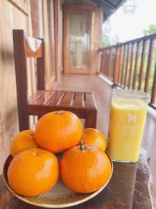 a plate of oranges on a table with a glass of orange juice at Trốn Homestay, Cao Bằng in Cao Bằng