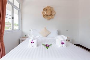 a white bed with two stuffed animals on it at Twin Villas Ao Nang in Ao Nang Beach
