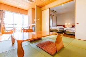 a living room with a dining table and a bedroom at Ooedo Onsen Monogatari Minoh Kanko Hotel in Minoo