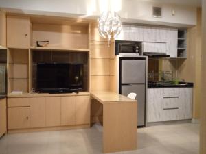 a kitchen with a refrigerator and a table in it at Grand Kamala Lagoon by 21 Room Netflix in Bekasi