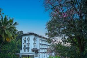 un edificio blanco con árboles delante de él en BPR - Asgiriya ,Kandy, en Kandy