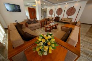 a living room with couches and a table with flowers on it at BPR - Asgiriya ,Kandy in Kandy