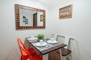 a dining room table with chairs and a mirror at Cozy BNB - Unit G in Batangas City