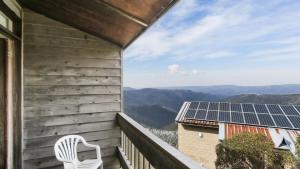 a white chair sitting on a balcony with solar panels at Shamrock 8 in Mount Hotham