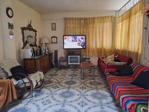 a living room with a couch and a tv at Casa Martha in Ciudad Nezahualcóyotl