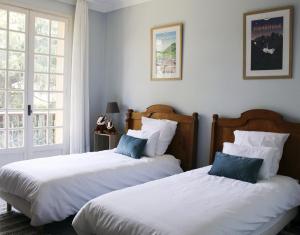 two beds sitting next to each other in a bedroom at Villa les Isards au cœur d'Argelès-Gazost in Argelès-Gazost