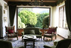 a living room with chairs and a large window at Villa les Isards au cœur d'Argelès-Gazost in Argelès-Gazost