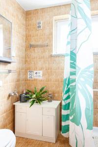 a bathroom with a plant on a white cabinet at Book house 