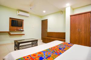 een slaapkamer met een bed met een kleurrijke deken bij FabHotel Uday Vilas in Indore
