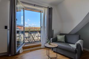 - un salon avec un canapé et une grande fenêtre dans l'établissement Landhaus Nienhagen, à Nienhagen