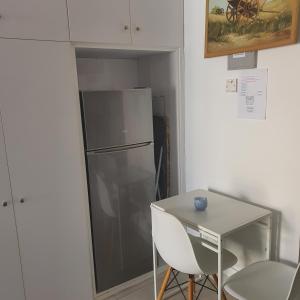 een kleine keuken met een koelkast en een tafel bij EMILIA 10 STUDIO in Polis Chrysochous