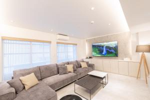 a living room with a couch and a tv at ONE WORLD Sakaisuji Honmachi in Osaka +43 photos