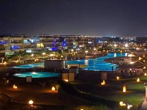 a group of pools lit up at night at شاليه فندقى سياحى in Ain Sokhna