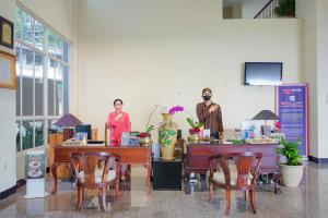 dwie kobiety stojące w pokoju ze stołami i krzesłami w obiekcie Royal Tretes View Hotel w mieście Prigen