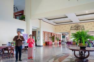 a man and a woman standing in a lobby at Royal Tretes View Hotel in Prigen