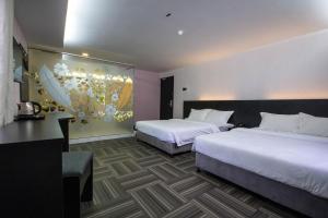北赖S Hotel Seberang Jaya的一间有两张床的酒店房间，墙上挂着一幅画