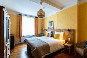 um quarto com uma cama grande e uma janela em Maison spacieuse unifamiliale. Gîte La Clochette em Bastogne