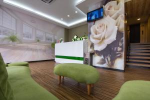 een lobby met een kamer met een tv en bloemen aan de muur bij S Hotel Seberang Jaya in Perai