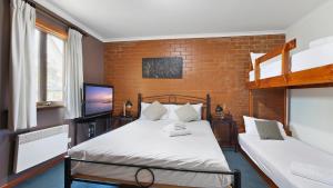 a bedroom with two beds and a tv at Lindsay Lachen in Mount Hotham