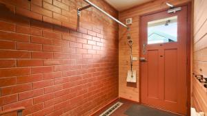 a brick hallway with a red door at Lindsay Lachen in Mount Hotham