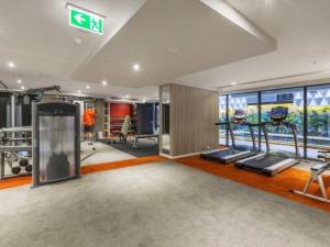 a gym with several treadmills and machines in it at Luxe at Paris end Melbourne in Melbourne