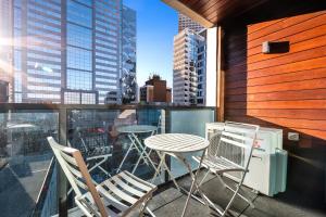 a balcony with a table and chairs and a view of a city at Luxe at Paris end Melbourne in Melbourne