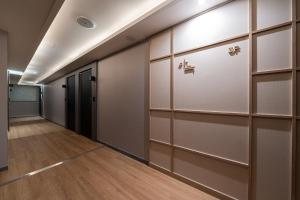 a walk in closet with sliding doors and wooden floors at The Hyoosik Aank Hotel Daejeon Yongjeon 1st Branch in Daejeon