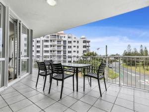 a patio with a table and chairs on a balcony at Kawana Beachside Getaway 1 Bedroom Apartment in Buddina