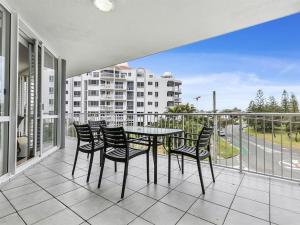 un patio con tavolo e sedie su un balcone di Kawana Beachside Getaway 1 Bedroom Apartment a Buddina