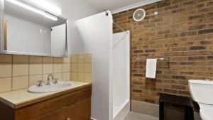 a bathroom with a sink and a brick wall at Lawlers 17 in Mount Hotham